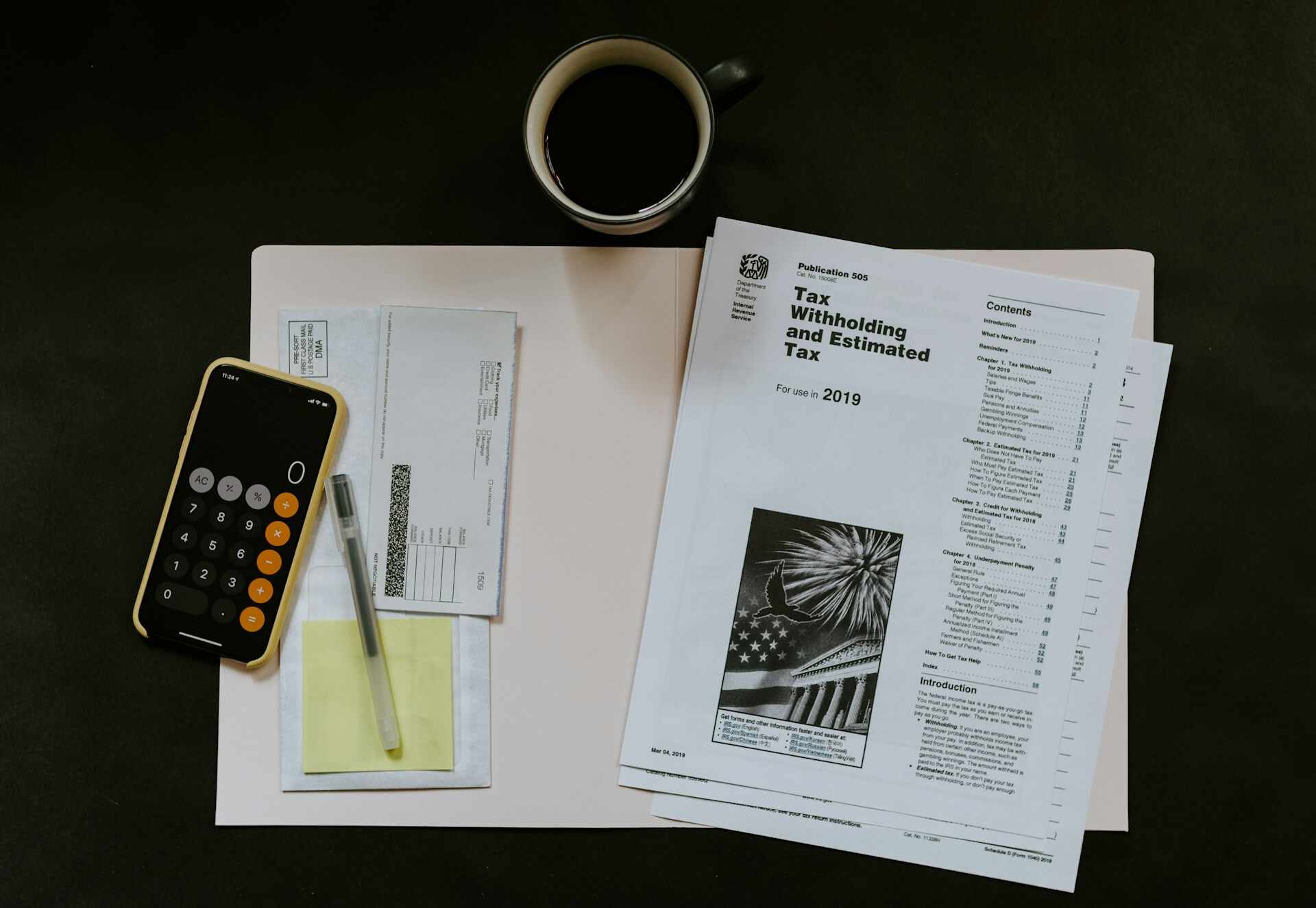 tax documents with pen and calculator on phone